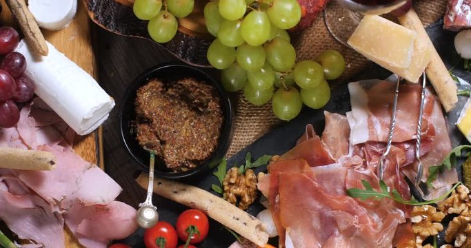 Dolly bird eye view of a platter of cured meat (charcuterie), ham, salami, pate and cheese