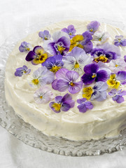 Carrot cake, decorated with edible flowers pansies