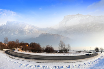 Samochód dostawczy zimą na drodze w górach, człowiek na szczycie góry.
