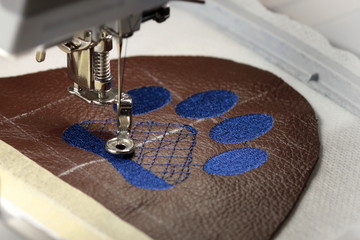 Embroidery with embroidery machine - dog paw on brown leather - fill
