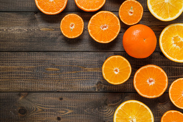 Cut oranges and mandarins on the wooden background