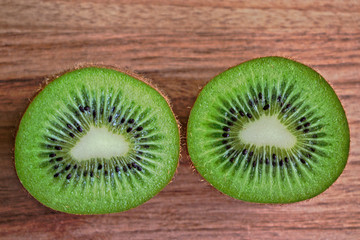 Closeup of two kiwi halves on a wooden table