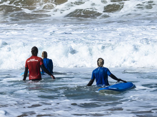 A couple of two surfers with their boards trying to get out trou