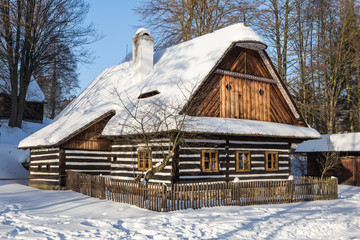 Traditional wooden timbered cottage in winter. Folk museum