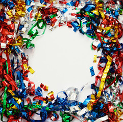 Scattered colorful confetti on white paper