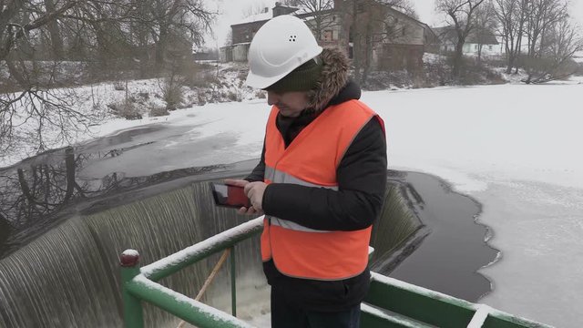 Engineer using tablet near floodgate