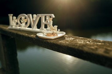 Wedding accessories. newlyweds rings and a wooden plaque in the form of text wedding