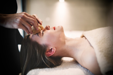 Masseur massaging face with heated objects