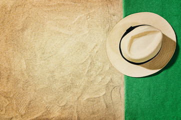 Top view of sandy beach with towel frame and summer accessories. Background with copy space and visible sand texture. Right border made of towel