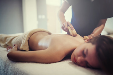 Obraz na płótnie Canvas Masseur massaging female on bed