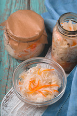 Sauerkraut in glass jars on turquoise boards close-up