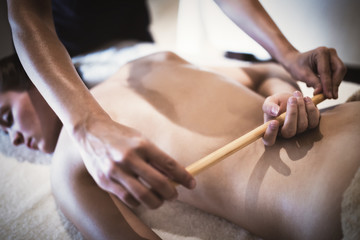 Masseur using sticks and rods to massage