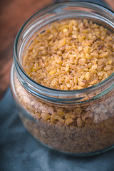 Grain bulgur in a glass jar on the napkin