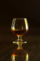 Glasses with white wine and cognac or whisky on mirror table. Celebrities composition.