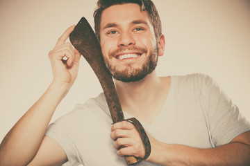 Young man shaving having fun with machete.