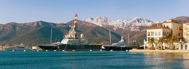 Fototapeta na wymiar Port in Tivat city with mountain background on a sunny day. Montenegro