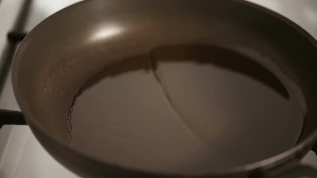 Close up shot of Pouring oil in a frying pan