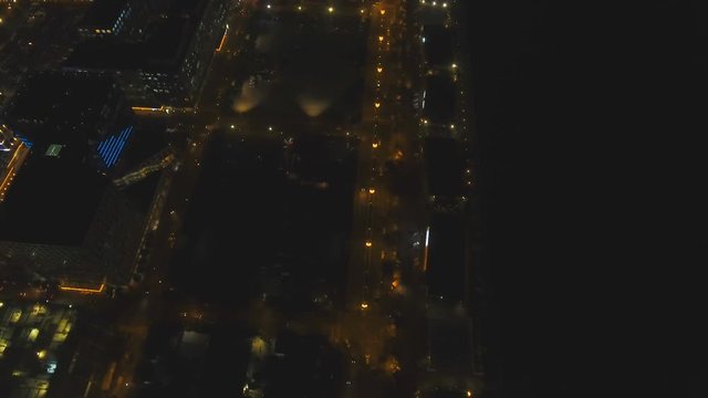 Aerial view skyline of Manila city by night. Aerial footage of illuminated skyscrapers and a highway. Fly over city with skyscrapers and buildings. Aerial skyline of Manila . Modern city by sea