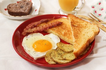 Valentine breakfast with heart shaped egg bacon bread toast cup of coffee served in red plate