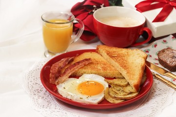Valentine breakfast with heart shaped egg bacon bread toast cup of coffee served in red plate