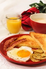 Valentine breakfast with heart shaped egg bacon bread toast cup of coffee served in red plate