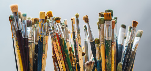 Paint Brushes on a blur background and artist is holding the brush
