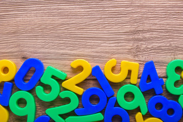 Colored numbers scattered on the wooden table. empty space for text