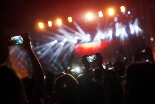 Crowd at concert recording atmosphere with their smart phones.