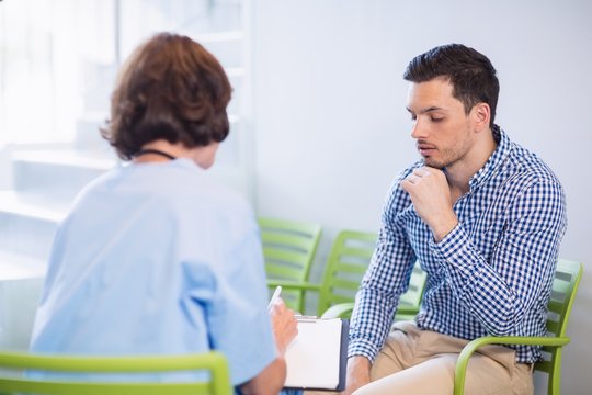 Nurse discussing a medical report with man