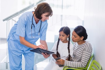 Nurse discussing a medical report with woman and patient