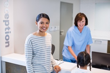 Obraz premium Portrait of smiling mother and daughter standing at counter