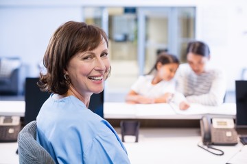 Portrait of smiling nurse sitting at desk