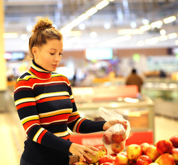 Fototapeta premium Middle-age woman buying vegetables at the market
