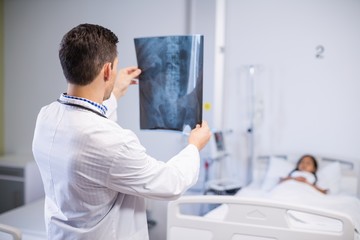 Naklejka na ściany i meble Doctor examining x-ray of patient