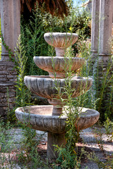 Old stone decorative fountain in the abandoned garden