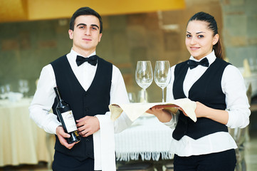 young waiter and waitress at service in restaurant
