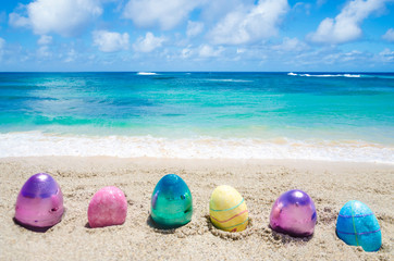Fototapeta na wymiar Easter color eggs on the beach near ocean