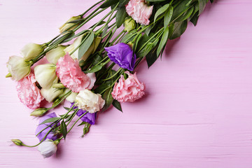 Bouquet of eustoma flowers on pink wooden background