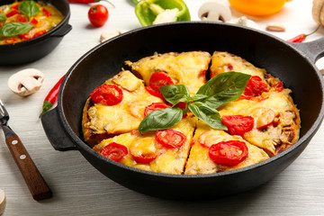 Freshly baked pizza in a pan on wooden background