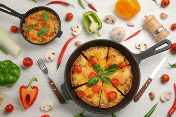 Freshly baked pizza in a pan on wooden background