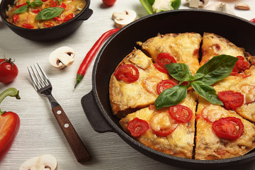 Freshly baked pizza in a pan on wooden background