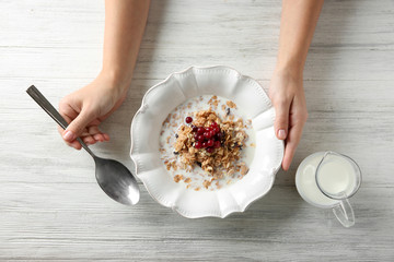 Female hands holding bowl with healthy breakfast, closeup