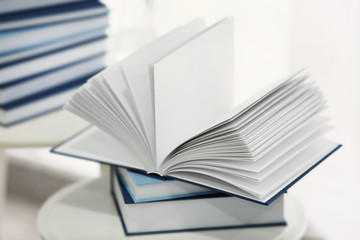 Pile of books on little table in the room, closeup