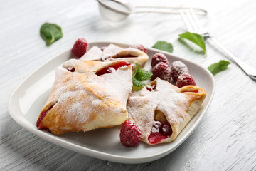 Tasty puff pastry with berries on plate