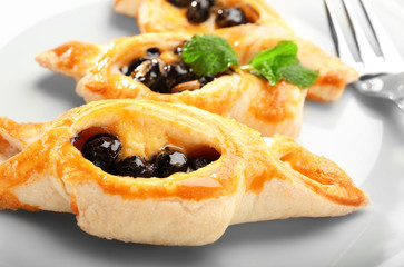 Tasty puff pastry with berries on plate, closeup