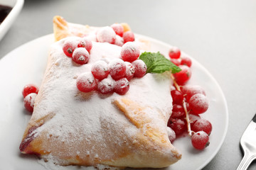Tasty puff pastry with berries on plate, closeup
