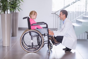 Smiling doctor talking to disable girl