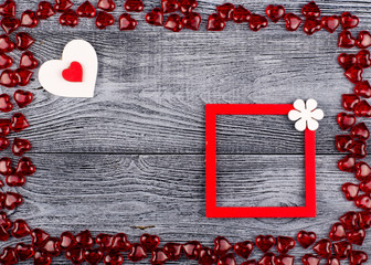 Gray wooden boards background with frame of red hearts