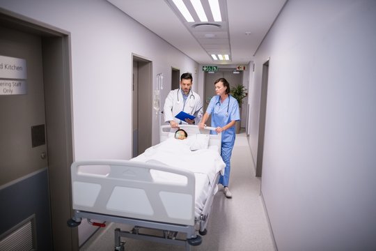 Doctors pushing emergency stretcher bed in corridor 