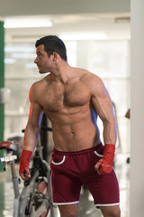 Fototapeta na wymiar Shirtless Muscular Boxer With Gloves In Gym